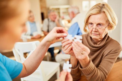 Mujer mayor haciendo un puzle para ver las diferencias entre demencia y Alzheimer.