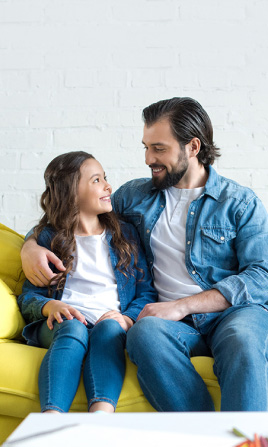 Padre e hija convesando en el sofá