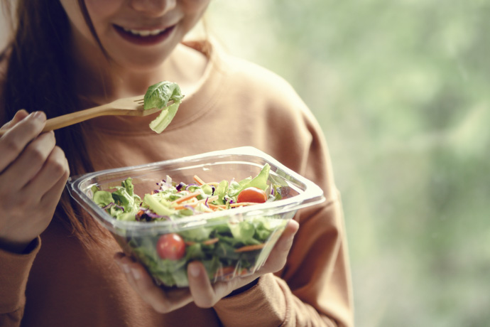 Mujer come ensalada saludable