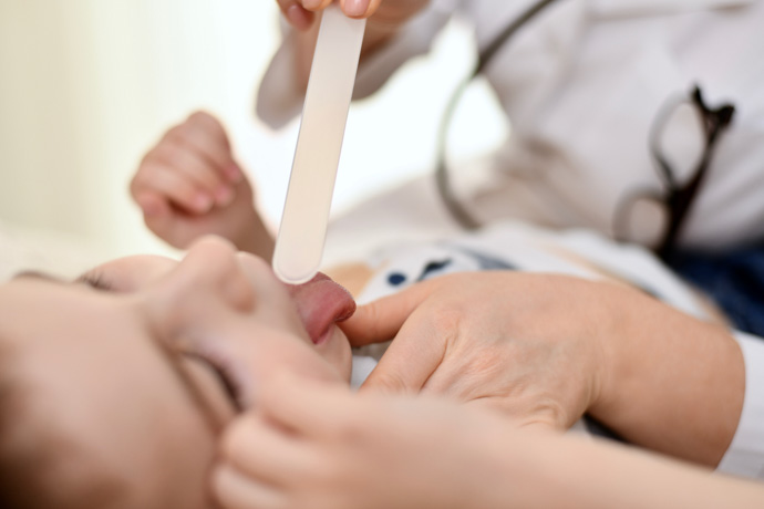 Niña con escarlatina auscultada por el médico.