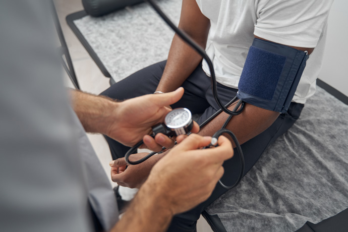 Profesional médico tomando la tensión a una persona con mareo y visión borrosa al hacer ejercicio.