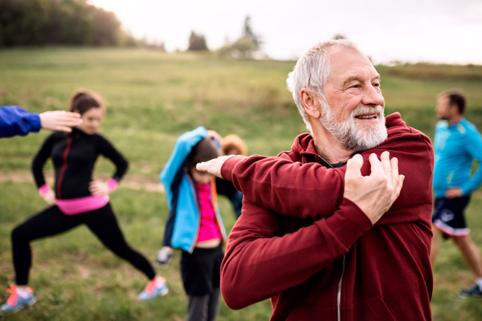 Grupo de personas mostrando cómo prevenir el Alzheimer haciendo ejercicio en un parque.