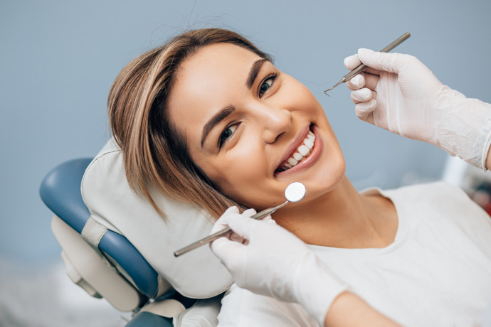 Mujer en el dentista previniendo la aparición de caries.