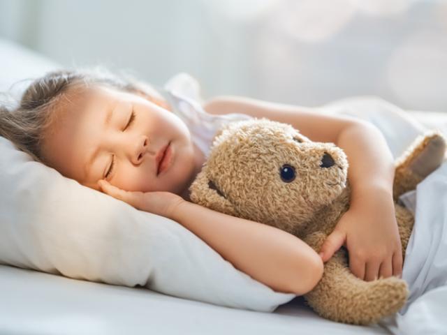 Niña durmiendo con su osito de peluche