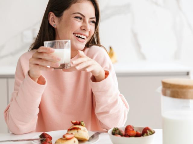 Mujer disfrutando de los beneficios de la leche para la salud.